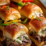 Plated Philly Cheesesteak sliders garnished with toppings, perfect for parties.